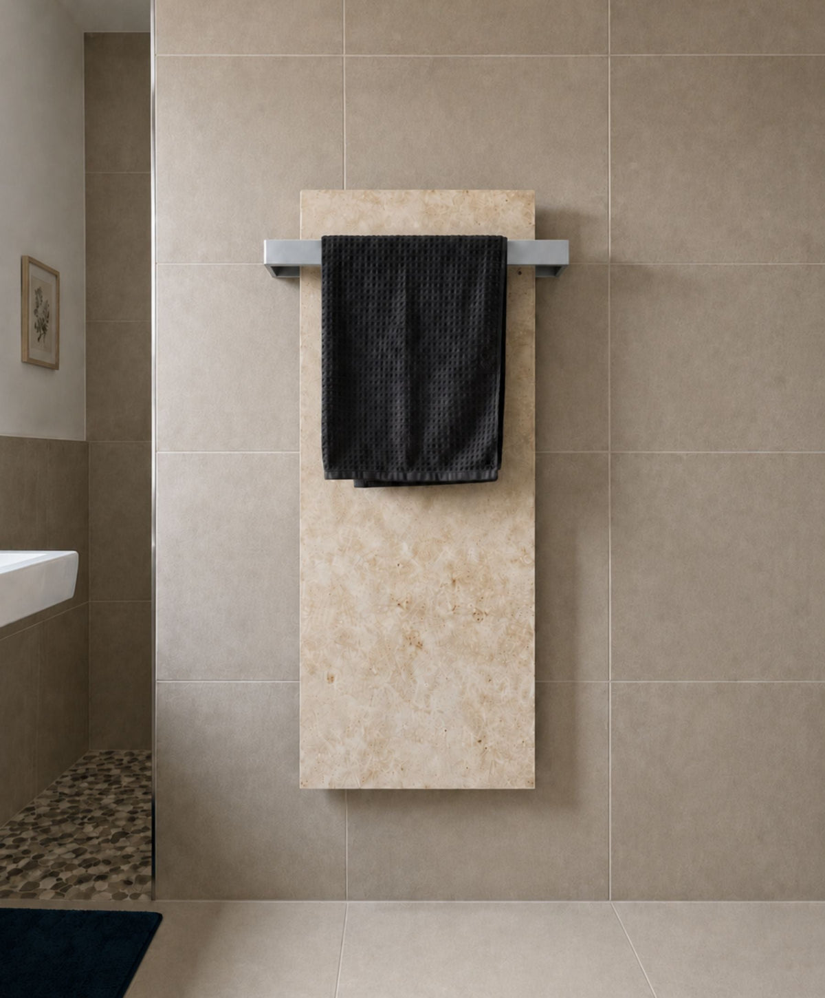 Marwona Jura-Natursteinheizung mit silberfarbenem Handtuchhalter im Badezimmer.